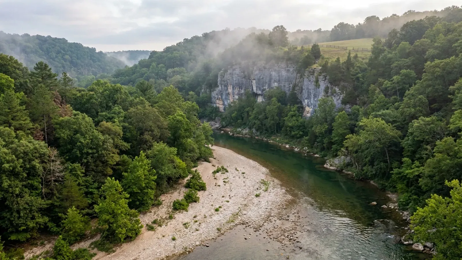 A clear spring-fed Ozark river over a chert gravel bar below a dolomite bluff, with oak-hickory and shortleaf pine slopes.